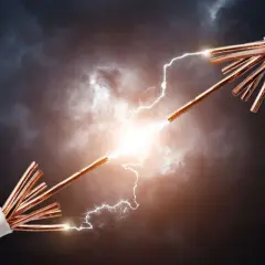 Dwa odsłonięte przewody miedziane iskrzą, ukazując, co to jest prąd elektryczny.