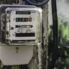 Podłączenie licznika prądu do drewnianego słupa. Urządzenie pokazuje zużycie energii elektrycznej.