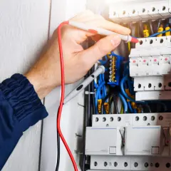 Elektryk sprawdza instalację. W elektryce "L" to przewód fazowy, kluczowy dla przepływu prądu.