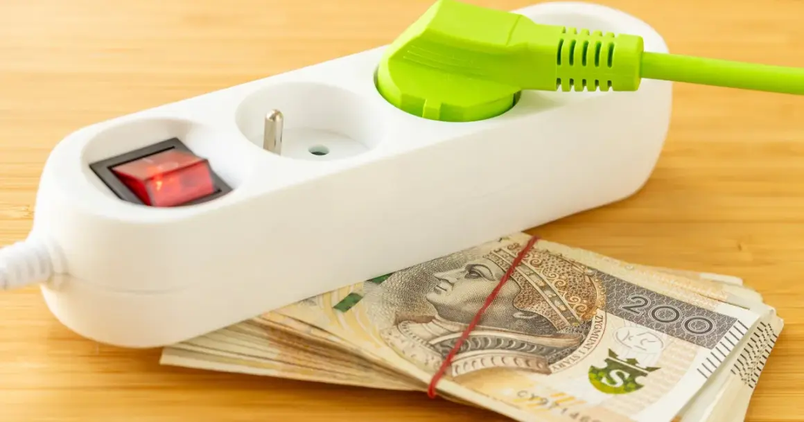 Przedłużacz z wtyczką i włącznikiem na stosie banknotów 200 zł. Oszczędzanie na tańszy prąd dla gospodarstw domowych.