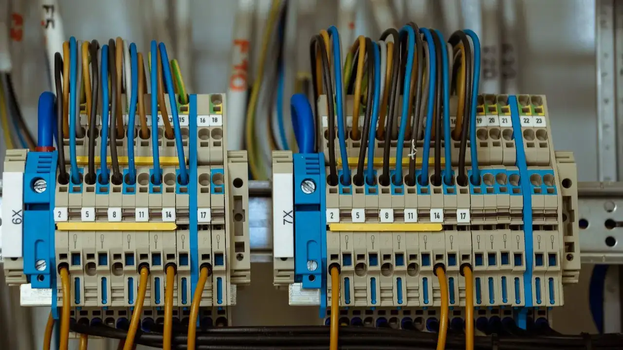 Zaciski elektryczne z kolorowymi przewodami, gotowe do podłączenia licznika prądu.