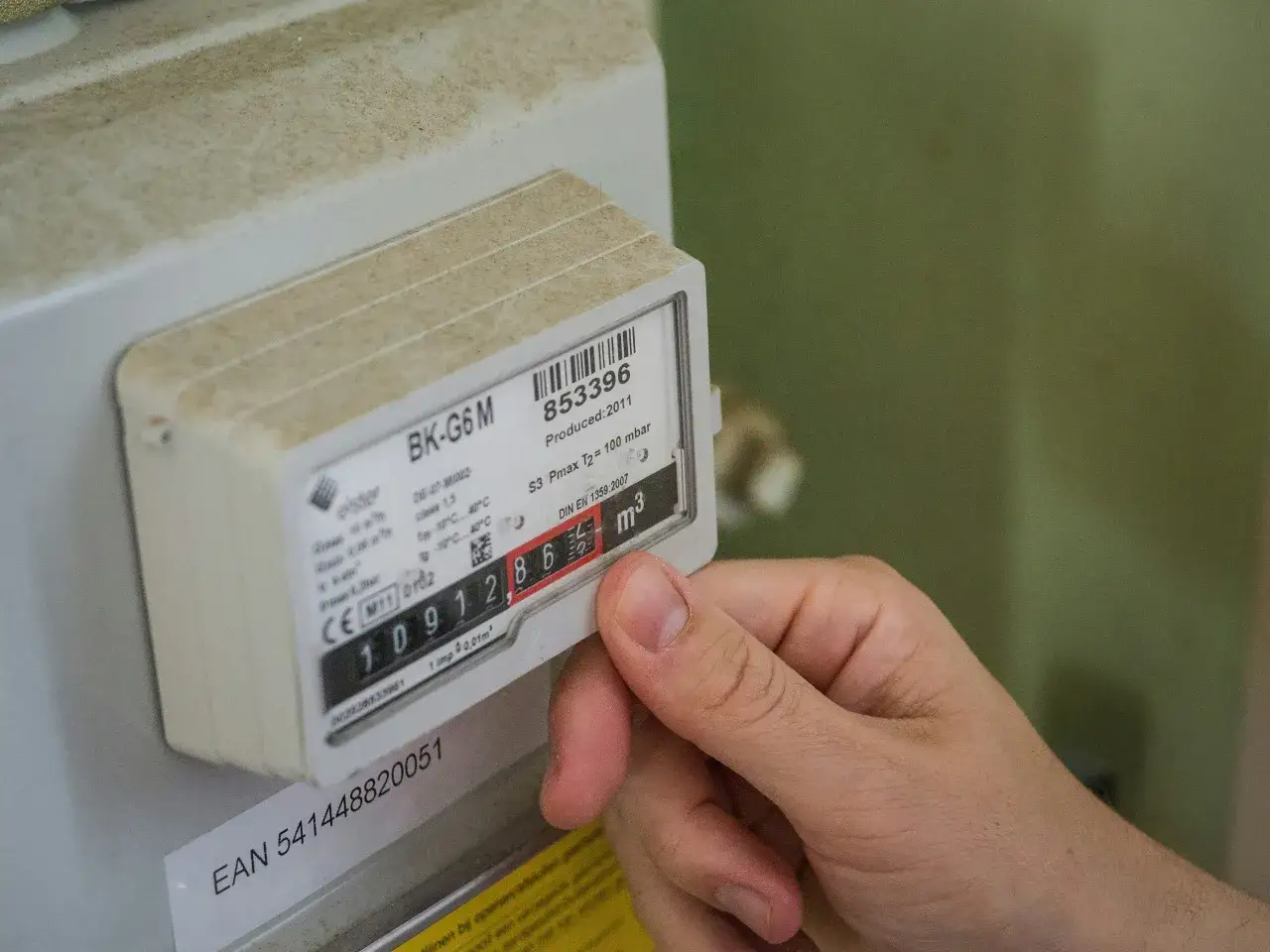 Dłoń wskazuje numer licznika prądu: 091286.