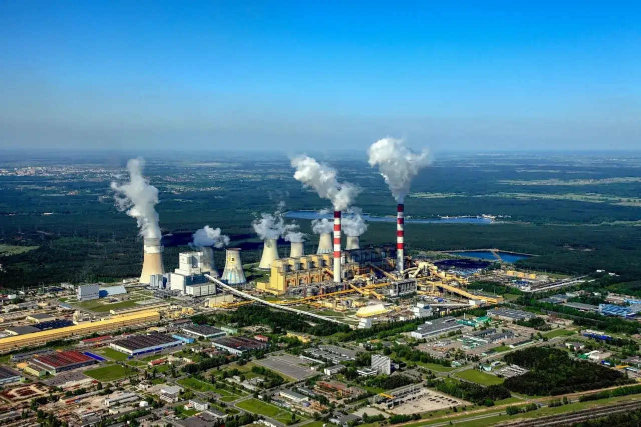 Ogromna elektrownia Bełchatów z dymiącymi kominami. Zastanawiasz się, ile prądu produkuje elektrownia Bełchatów? To potężne źródło energii.